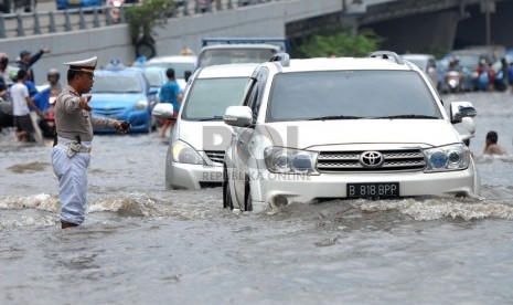 Sejumlah kendaraan melintasi banjir yang merendam ruas Jalan S. Parman di depan Universitas Trisakti, Grogol, Jakarta Barat, Sabtu (18/1). (Republika/Rakhmawaty La'lang)