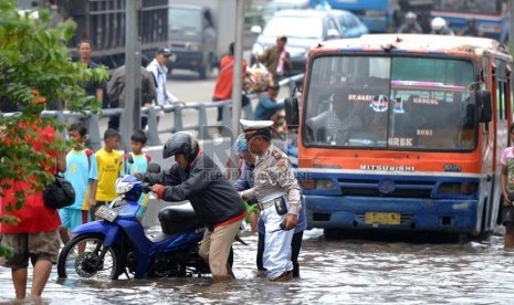 Sejumlah kendaraan melintasi banjir yang merendam ruas Jalan S. Parman di depan Universitas Trisakti, Grogol, Jakarta Barat, Sabtu (18/1). (Republika/Rakhmawaty La'lang)