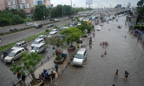 Sejumlah kendaraan melintasi banjir yang merendam ruas Jalan S. Parman di depan Universitas Trisakti, Grogol, Jakarta Barat, Sabtu (18/1). (Republika/Rakhmawaty La'lang)