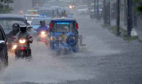   Sejumlah kendaraan melintasi genangan air di kawasan Matraman, Jakarta Timur.    (Republika/Agung Supriyanto)