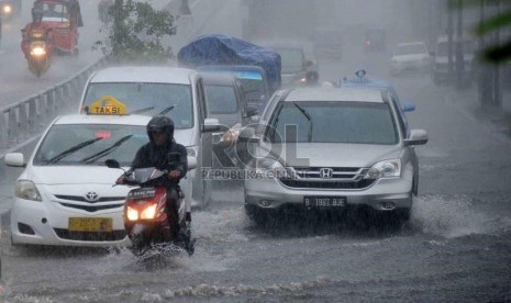   Sejumlah kendaraan melintasi genangan air di kawasan Matraman, Jakarta Timur, Rabu (8/1).    (Republika/Agung Supriyanto)