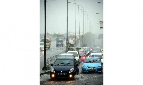   Sejumlah kendaraan melintasi genangan air di kawasan Matraman, Jakarta Timur, Rabu (8/1).    (Republika/Agung Supriyanto)