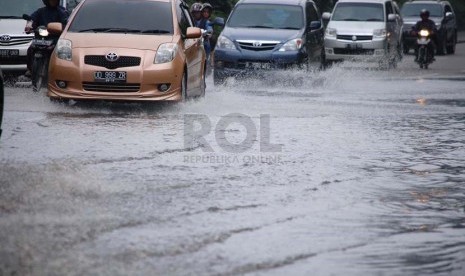 Sejumlah kendaraan melintasi genangan air yang berada di Jalan Gatot Subroto, Jakarta Pusat, Senin (10/3).  (foto : Raisan Al Farisi)