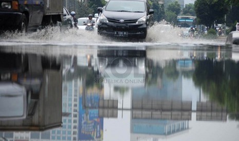 Sejumlah kendaraan melintasi genangan air yang berada di Jalan Gatot Subroto, Jakarta Pusat, Senin (10/3).  (foto : Raisan Al Farisi)