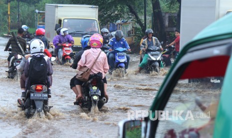 Sejumlah kendaraan melintasi genangan air yang mulai membanjiri Jalan Anggadireja, Kecamatan Baleendah, Kabupaten Bandung, Kamis (8/11).