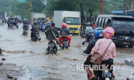 Sejumlah kendaraan melintasi genangan air yang mulai membanjiri Jalan Anggadireja, Kecamatan Baleendah, Kabupaten Bandung, Kamis (8/11).