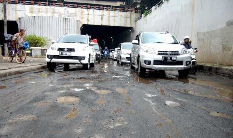 Sejumlah kendaraan melintasi jalan rusak di underpass Pasar Gembrong, Jakarta Timur, Jumat (28/2). (foto : Raisan Al Farisi)