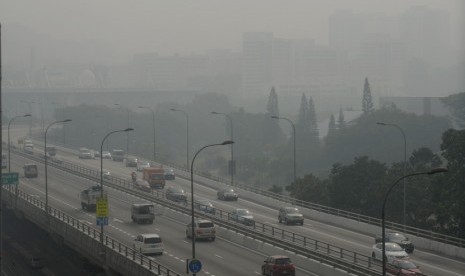  Sejumlah kendaraan melintasi jalan tol yang diselubungi kabut asap di Singapura,Kamis (20/6).  