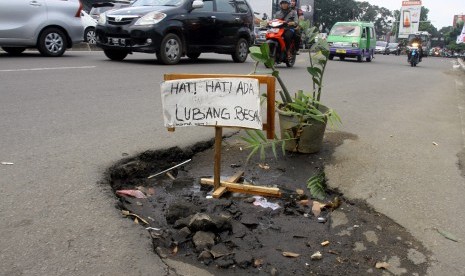 Sejumlah kendaraan melintasi jalan yang rusak berlubang di Jalan KS Tubun, Kota Bogor, Jawa Barat, Senin (11/4). 