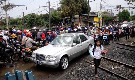   Sejumlah kendaraan melintasi pintu perlintasan kereta api di Pesanggrahan, Bintaro, Jakarta, Rabu (11/12).     (Republika/Yasin Habibi)