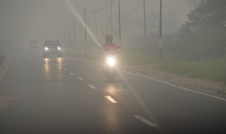 Sejumlah kendaraan menembus kabut asap yang menyelimuti Kota Palangka Raya, Kalteng, Selasa (27/10). 