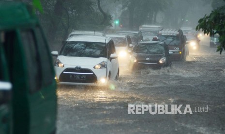 Sejumlah kendaraan menerobos banjir di Jalan Supratman, akibat meluapnya drainase saat hujan deras yang mengguyur Kota Bandung, Kamis (22/11).