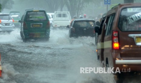 Sejumlah kendaraan menerobos banjir akibat luapan air drainase saat hujan deras yang mengguyur Kota Bandung, Kamis (22/11).