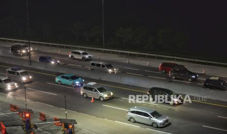 Sejumlah kendaraan pemudik memperlambat laju kendaraanya  saat memasuki Gerbang Tol Cikampek Utama, Jawa Barat, Sabtu (6/4/2024) dini hari.  Volume kendaraan yang melintasi gerbang tol tersebut mengalami peningkatan seiring pemberlakuan skema lalu lintas contraflow dan one way di jalan Tol TransJawa.