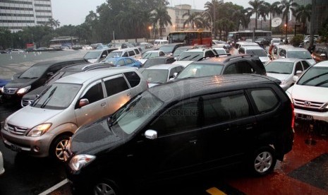   Sejumlah kendaraan terjebak kemacetan ketika hujan deras mengguyur kawasan Jalan Thamrin, Jakarta, Jumat (21/12).   (Republika/Yasin Habibi)