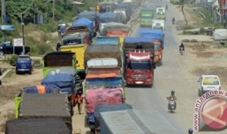 Sejumlah kendaraan truk berjalan merayap di ruas Jalan Ir Soekarno Hatta Kota Bandarlampung, Selasa (9/07). Jalan lintas Sumatera itu menjadi salah satu titik rawan macet saat arus mudik karena pengerjaan pelebaran badan jalan yang belum rampung sejak bebe