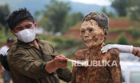 Sejumlah kerabat membersihkan jenazah keluarga saat ritual Manene di Pangala, Kecamatan Rindingallo, Kabupaten Toraja Utara, Sulawesi Selatan, Jumat (27/8/2021). Ritual Manene menjadi salah satu upacara sakral yang berlangsung secara turun temurun di kalangan masyarakat Toraja sebagai bentuk penghormatan kepada leluhur mereka yang telah wafat. 