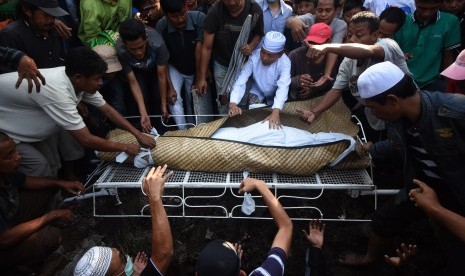 Sejumlah kerabat mengangkat jenazah terpidana mati kasus penyalahgunaan narkoba berkewarganegaraan Indonesia, Freddy Budiman ke liang lahat di Tempat Pemakaman Umum Mbah Ratu, Surabaya, Jawa Timur, Jumat (29/7).