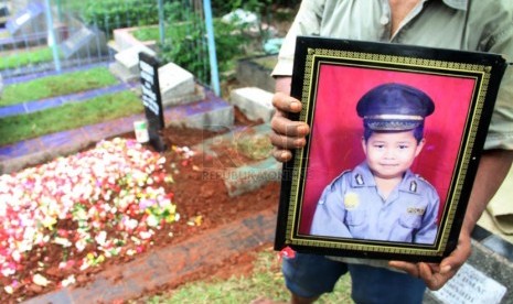   Sejumlah kerabat tengah memanjatkan doa saat pemakaman almarhum Renggo Kadapi di TPU Kampung Asem, Halim, Jakarta Timur, Ahad (4/5).  (Republika/Yasin Habibi)