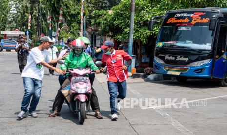 Sejumlah kondektur mengejar calon penumpang yang baru tiba di Terminal Kalideres, Jakarta Barat, Senin (26/4/2021). Meski adanya aturan larangan mudik mulai dari 22 April - 24 Mei 2021, armada perusahaan otobus (PO) tetap beroperasi di Terminal Kalideres.