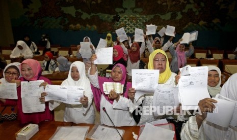 Sejumlah korban kasus penipuan dana Umroh First Travel menujukkan bukti pembayaran mereka saat melakukan audiensi kepada perwakilan Komisi VIII dan Fraksi PPP di Kompleks Parlemen, Jakarta, Jumat (18/8). 