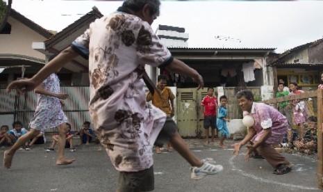 Sejumlah lelaki berpakaian perempuan bermain bola dalam perayaan HUT ke-68 RI