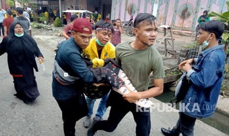 Sejumlah mahasiswa menggotong rekannya yang pingsan akibat terkena gas air mata di depan Kantor DPRK Aceh Barat, Aceh, Kamis (26/9/2019).