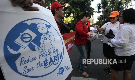 Sejumlah mahasiswa menukar kantong plastik milik warga dengan kantong kain di Surabaya, Jawa Timur, Minggu (22/4).