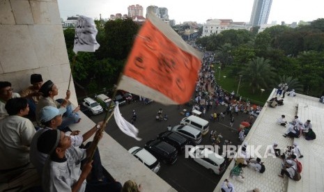 Sejumlah massa aksi 313 mengibarkan bendera sebelum melaksanakan Shalat Jumat bersama di Masjid Istiqlal, Jakarta, Jumat (31/3)