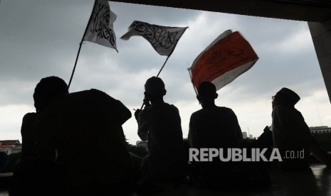 Sejumlah massa aksi 313 mengibarkan bendera sebelum melaksanakan Shalat Jumat bersama di Masjid Istiqlal, Jakarta, Jumat (31/3)