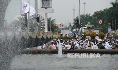 Sejumlah massa berdoa bersama sebelum melaksanakan Shalat Jumat saat aksi di Bundaran Patung Kuda, Jakarta, Jumat (4/11). (Republika/Raisan Al Farisi)