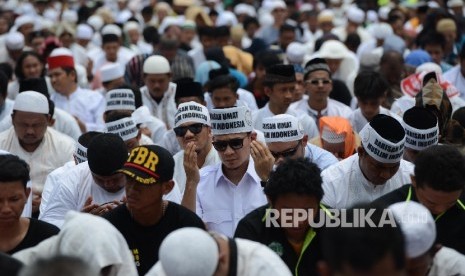 Sejumlah massa berdoa bersama seusai melaksanakan Shalat Jumat saat aksi di Bundaran Patung Kuda, Jakarta, Jumat (4/11). (Republika/Raisan Al Farisi)