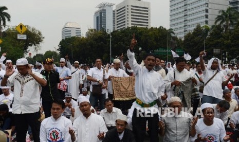 Sejumlah massa berdoa bersama seusai mengikuti Shalat Jumat di Bundaran Patung Kuda, Jakarta, Jumat (4/11). 