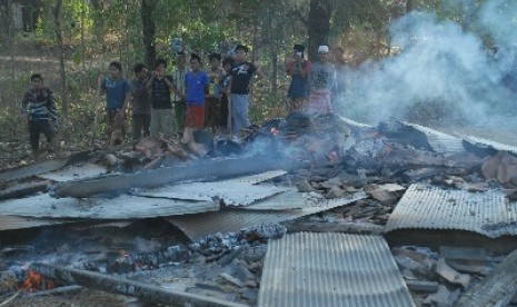 Sejumlah massa menyaksikan puing pemukiman warga Syiah yang dibakar, di Desa Karanggayam, Omben, Sampang, Jawa Timur, Ahad (26/8).