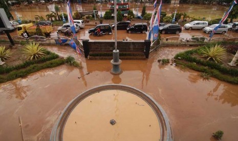  Sejumlah mobil melintas di depan kantor walikota yang penuh lumpur akibat terendam banjir di kantor Walikota Manado, Sulawesi Utara, Kamis (16/1).    (Antara/Fiqman Sunandar)