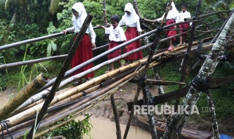 Sejumlah murid SD melewati jembatan bambu yang sudah rapuh.   (ilustrasi) 