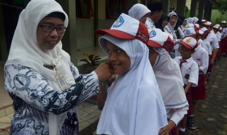 Sejumlah murid Sekolah Dasar(SD) berjajar antre untuk bersalaman kepada gurunya sambil mengucapkan Selamat Hari Guru di halaman Sekolah Dasar 1 Mlati Lor Kudus, Jawa Tengah, Jumat (25/11).