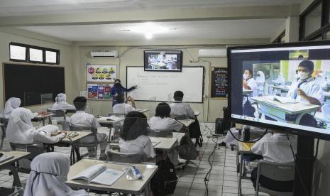 Sejumlah murid SMP Nassa School mengikuti pembelajaran secara hibrid atau kombinasi antara tatap muka terbatas dengan secara daring di Pondok Melati, Bekasi, Jawa Barat, Senin (10/1/2022). Dinas Pendidikan Jawa Barat menunda Pelaksanaan Tatap Muka (PTM) 100 persen hingga akhir Januari 2022 sambil menunggu capaian vaksinasi dan perkembangan kasus COVID-19.