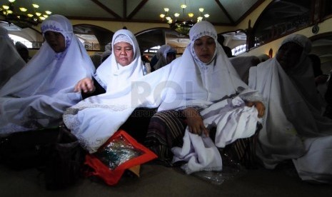 Mencoba mukena yang dibagikan Yayasan Masjid Nusantara(YMN).