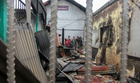 Sejumlah narapidana berada di dekat puing bangunan Rutan yang hangus terbakar pasca kerusuhan di Rutan Kelas II B Siak Sri Indrapura, Kabupaten Siak, Riau, Sabtu (11/5/2019). 