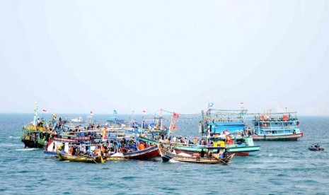 Sejumlah nelayan bersama keluarga menaiki kapal mengikuti prosesi Nadran Nelayan di lepas pantai Muara Karang, Jakarta, Selasa (10/6). Nadran merupakan upacara adat para nelayan di pesisir pantai utara Jawa, seperti Subang, Indramayu dan Cirebon yang bertu