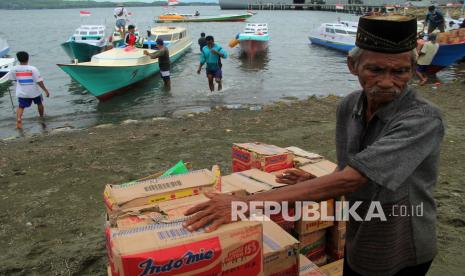 Sejumlah nelayan memindahkan bantuan logistik di MakoLanal Mamuju, Sulawesi Barat, Senin (25/1). TNI AL menyalurkan bantuan logistik kepada nelayan pesisir yang terdampak gempa Sulawesi Barat. 