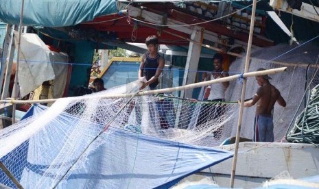  Sejumlah nelayan memperbaiki jaring di dermaga Pantai Karangsong, Kabupaten Indramayu, Kamis (20/2). (Republika/Edi Yusuf)