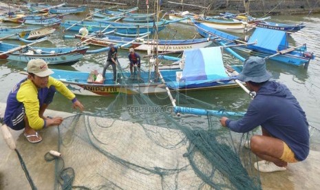   Sejumlah nelayan yang tidak dapat melaut akibat cuaca buruk, memperbaiki jaring di Pantai Jayanti, Kecamatan Cidaun, Kabupaten Cianjur, Senin (13/1).   (Republika/Edi Yusuf)