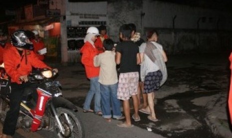 Sejumlah orang membagi-bagikan makanan sahur kepada warga di pinggir jalan dalam acara 