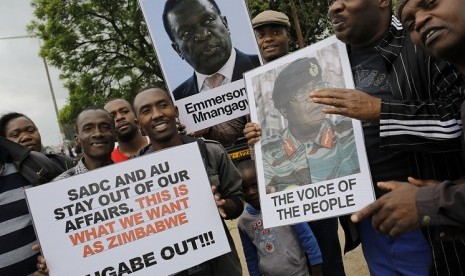 Sejumlah orang membawa poster yang berisikan tuntutan agar Presiden Zimbabwe Robert Mugabe mundur, di Harare, Zimbabwe.