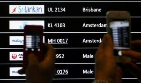 Sejumlah orang memotret layar yang menunjukkan kedatangan pesawat Maskapai Malaysia Airlines MH-17 di Bandara Internasional Kuala lumpur, Jumat (18/7).
