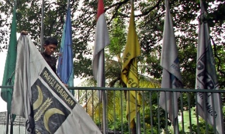 Sejumlah orang menurunkan bendera PKS yang terpasang di kantor Sekretariat Gabungan (Setgab), Jakarta, Rabu (4/4). 