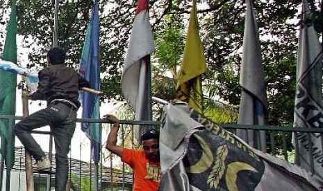 Sejumlah orang menurunkan bendera PKS yang terpasang di kantor Sekretariat Gabungan (Setgab).