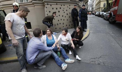  Sejumlah orang yang terluka duduk di trotoar setelah ledakan yang terjadi di pusat kota Praha, Republik Ceko, Senin (29/4).    (AP/Petr David Josek)